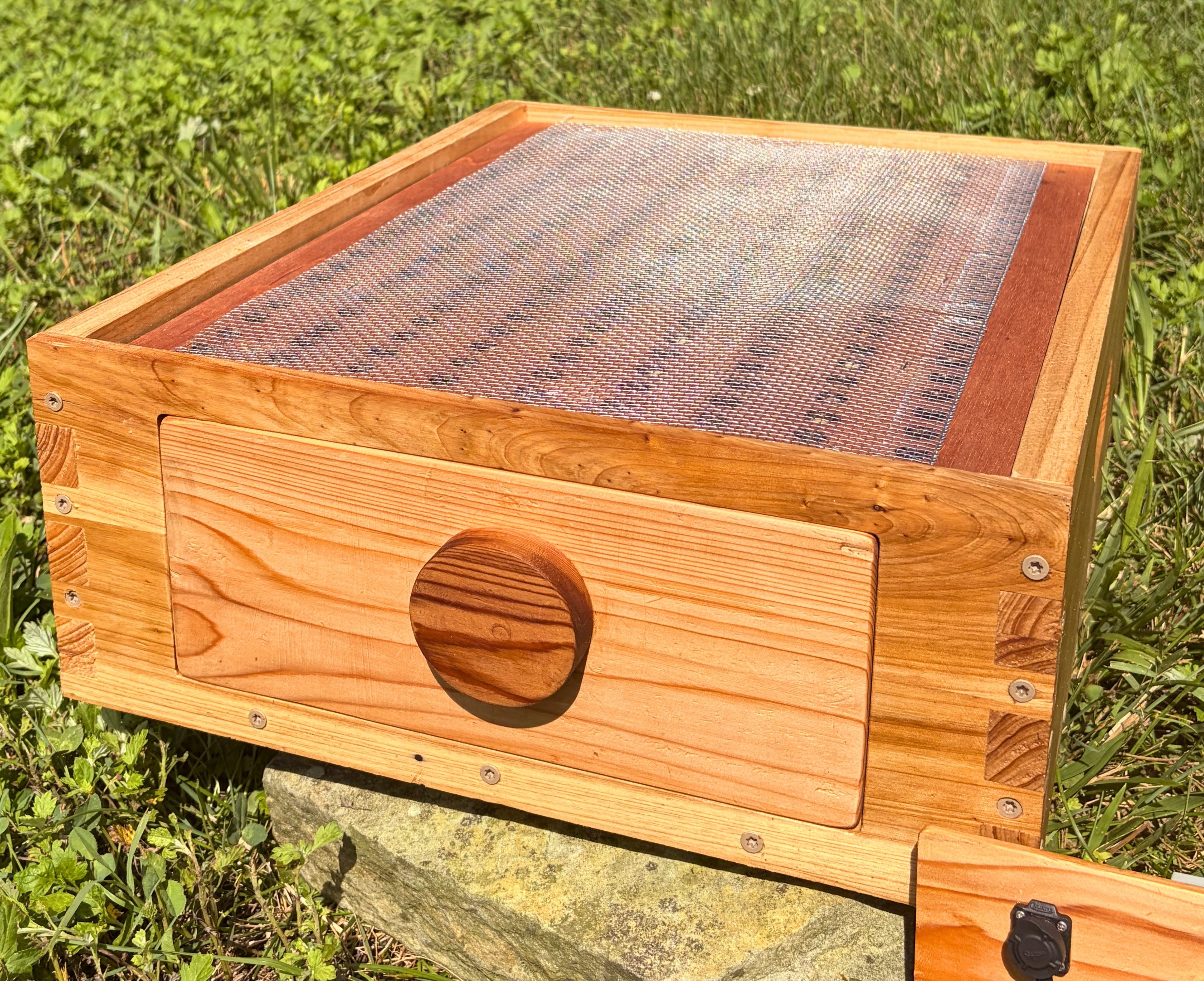 An alternative detailed product view of the wooden ThermaHive V2 bottom box frame with the blank insert fully slid into place.